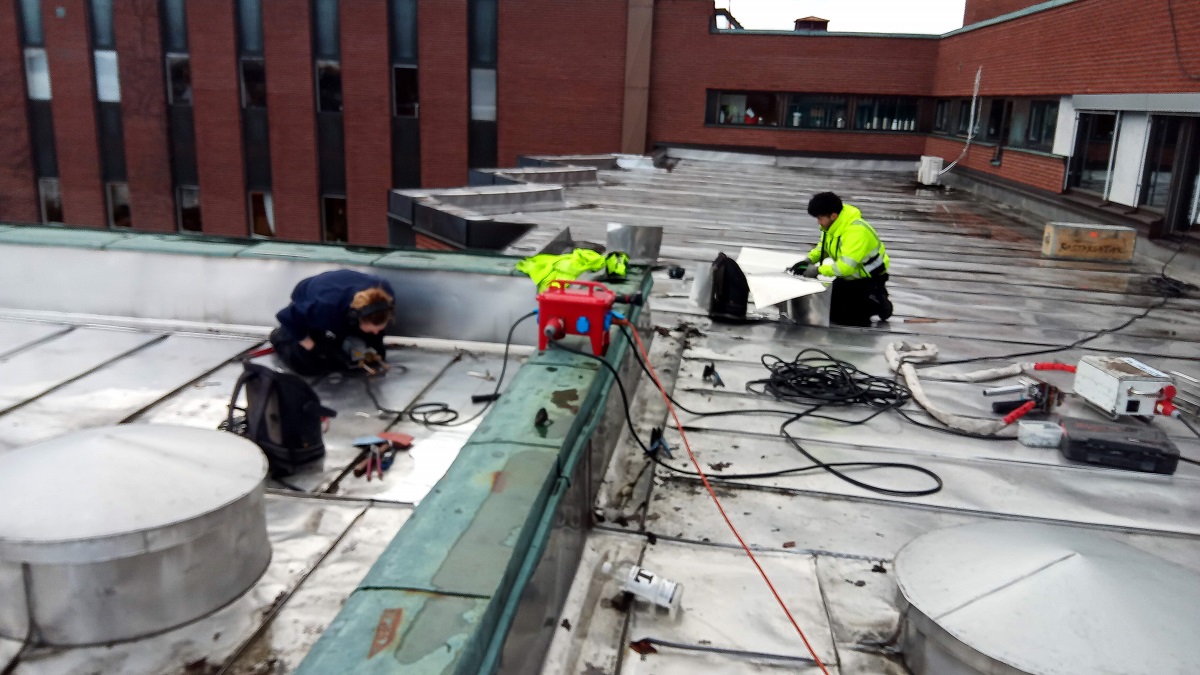 Reparation pågar av hugghål i äldre rostfritt tak.